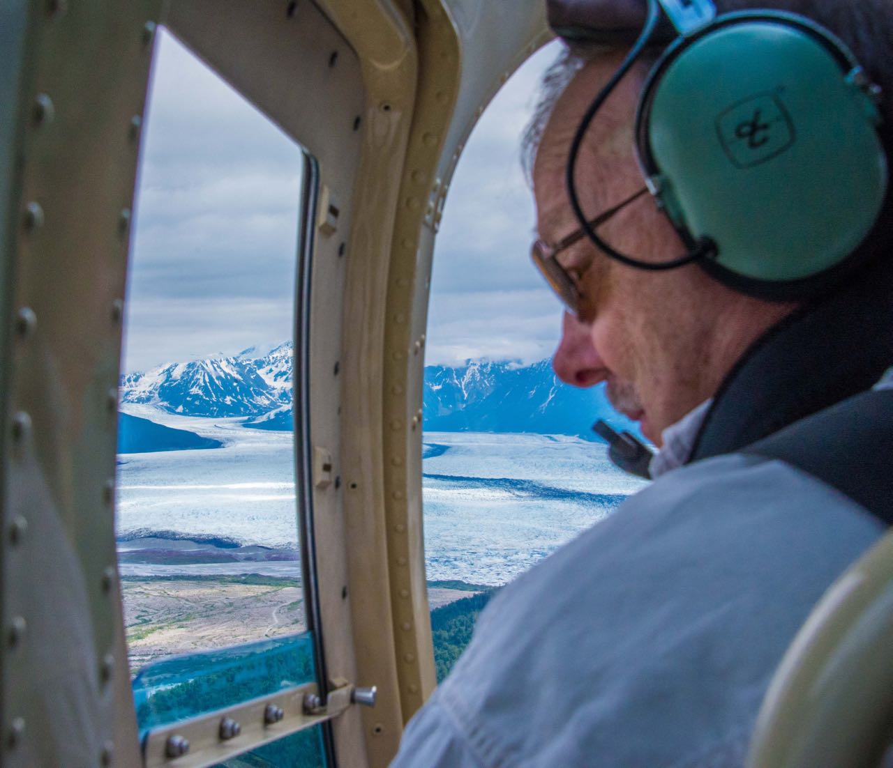 Looking out the window of helicopter flying over glaciers in Alaska